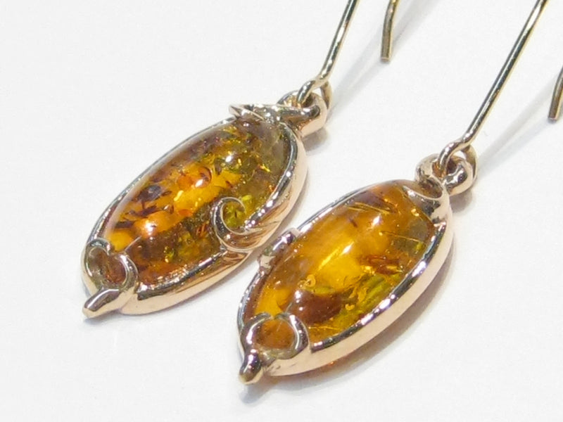 Pair of very large oval ambers set in rose gold earrings.