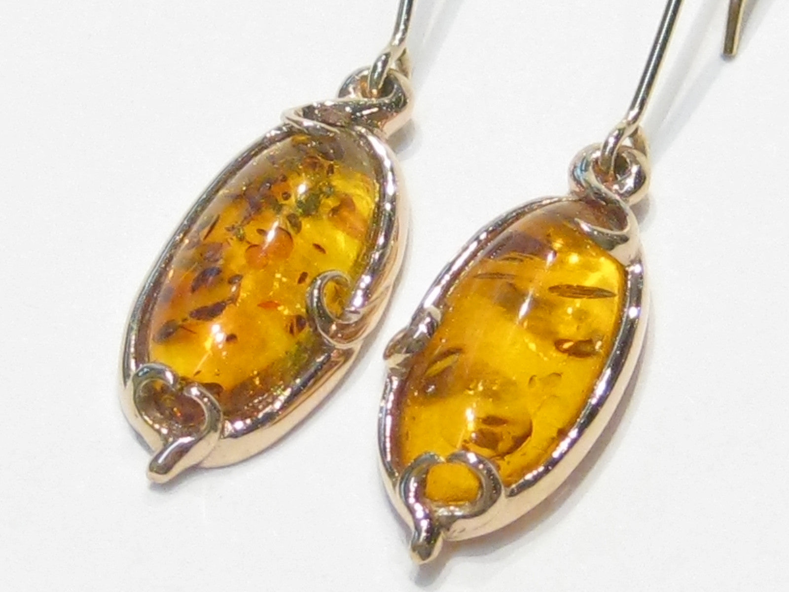 Pair of very large oval ambers set in rose gold earrings.