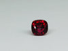 Deep red spinel gem, white background.