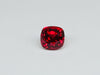 Deep red spinel gem, white background.