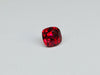 Deep red spinel gem, white background.