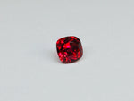 Deep red spinel gem, white background.