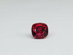 Deep red spinel gem, white background.