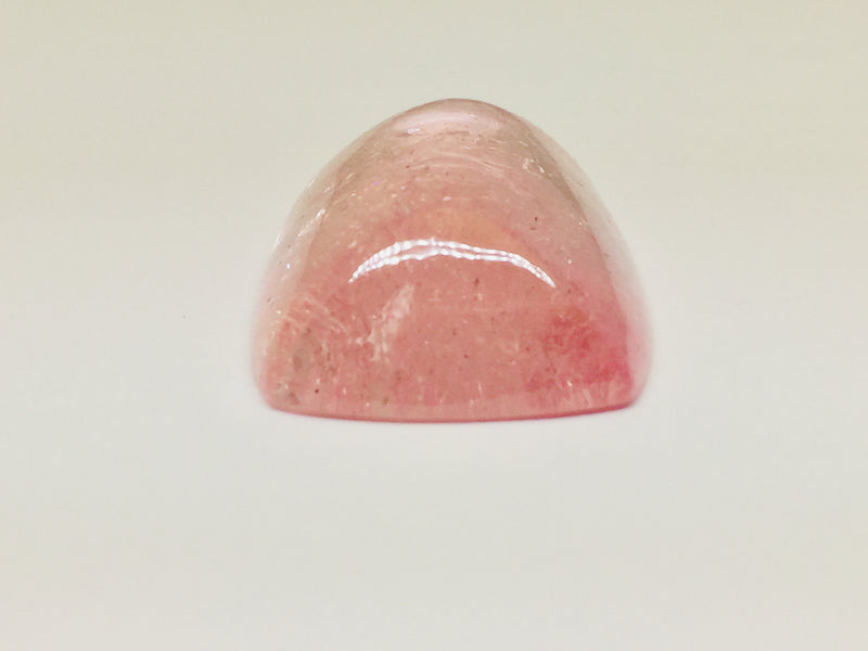 Very large cabochon of morganite (pink beryl) gem, white background.