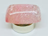 Very large cabochon of morganite (pink beryl) gem, white background.