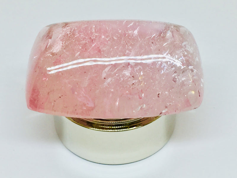 Very large cabochon of morganite (pink beryl) gem, white background.