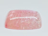 Very large cabochon of morganite (pink beryl) gem, white background.