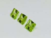 Three buff top peridot gems, white background.