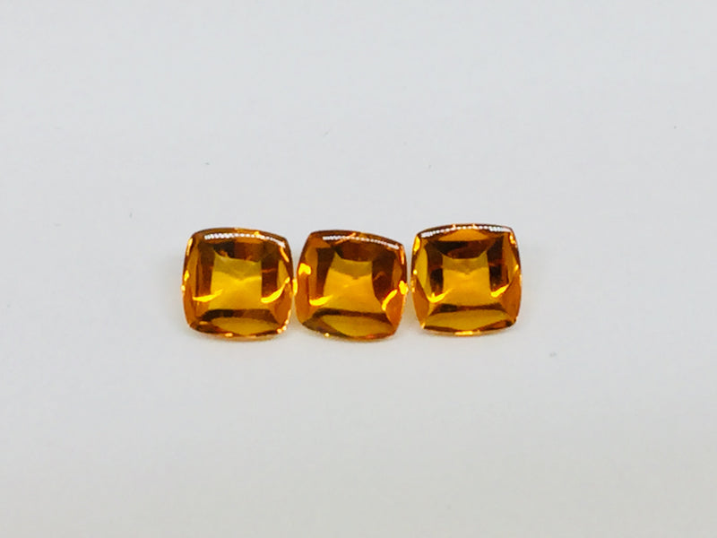 Three buff top citrine gems, white background.