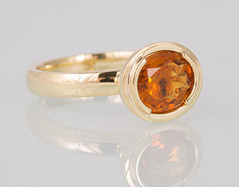 Yellow gold ring with oval bright orange citrine gem.