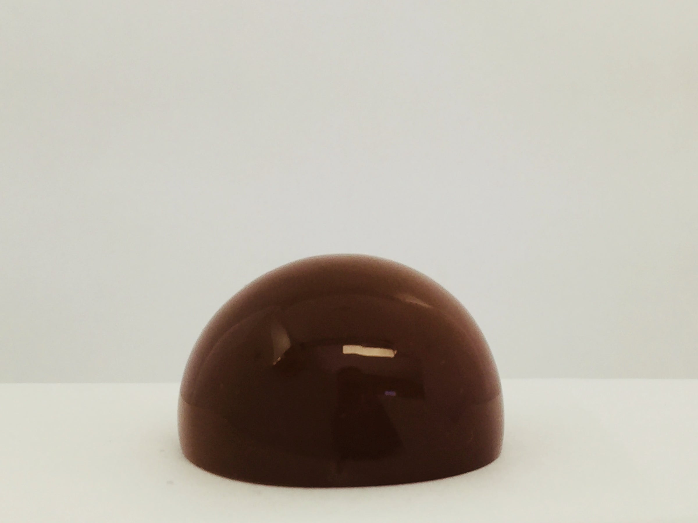 Very large round mocha coloured moonstone cabochon gem, white background.