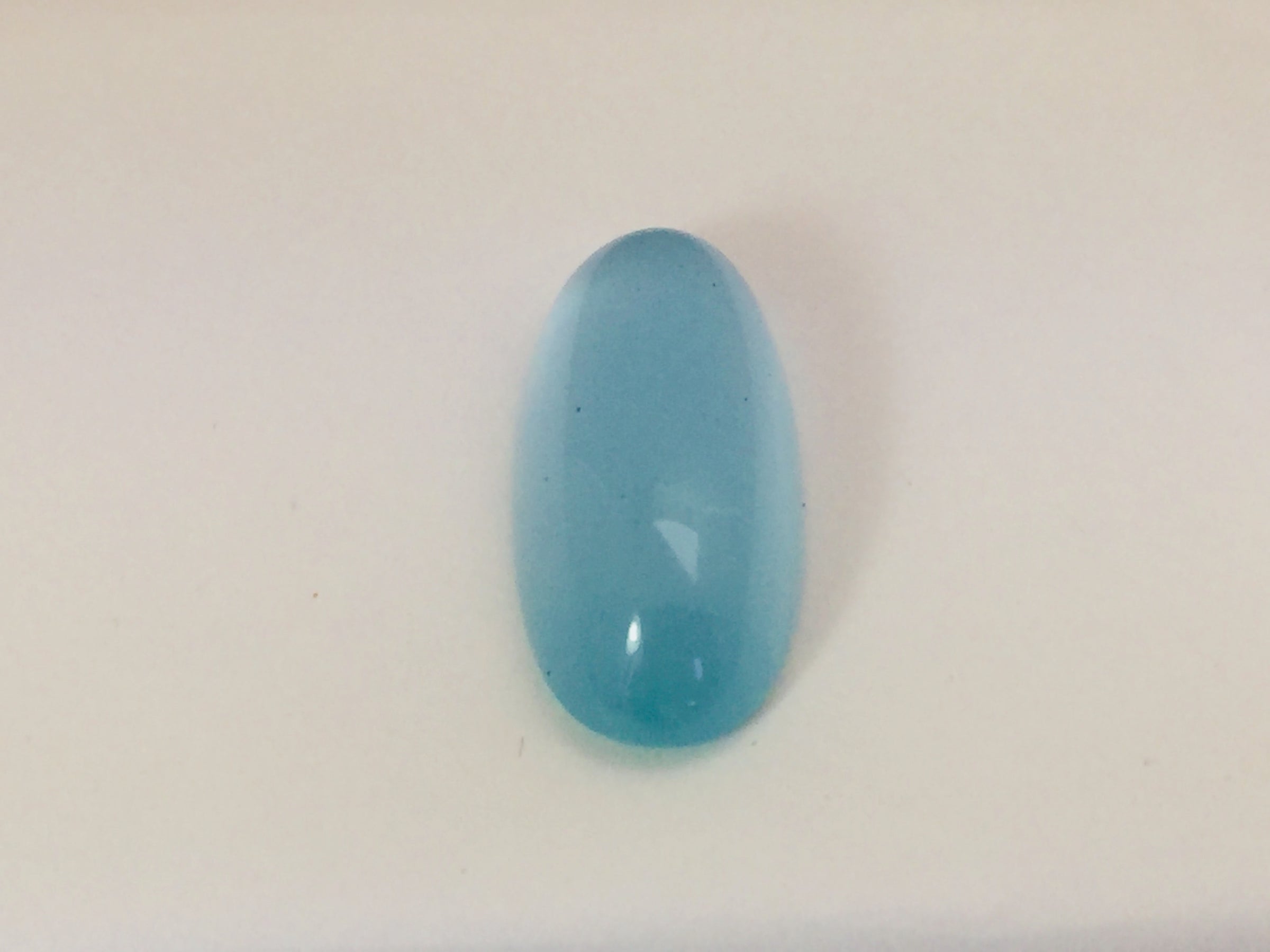 Long light blue aquamarine gem, white background.