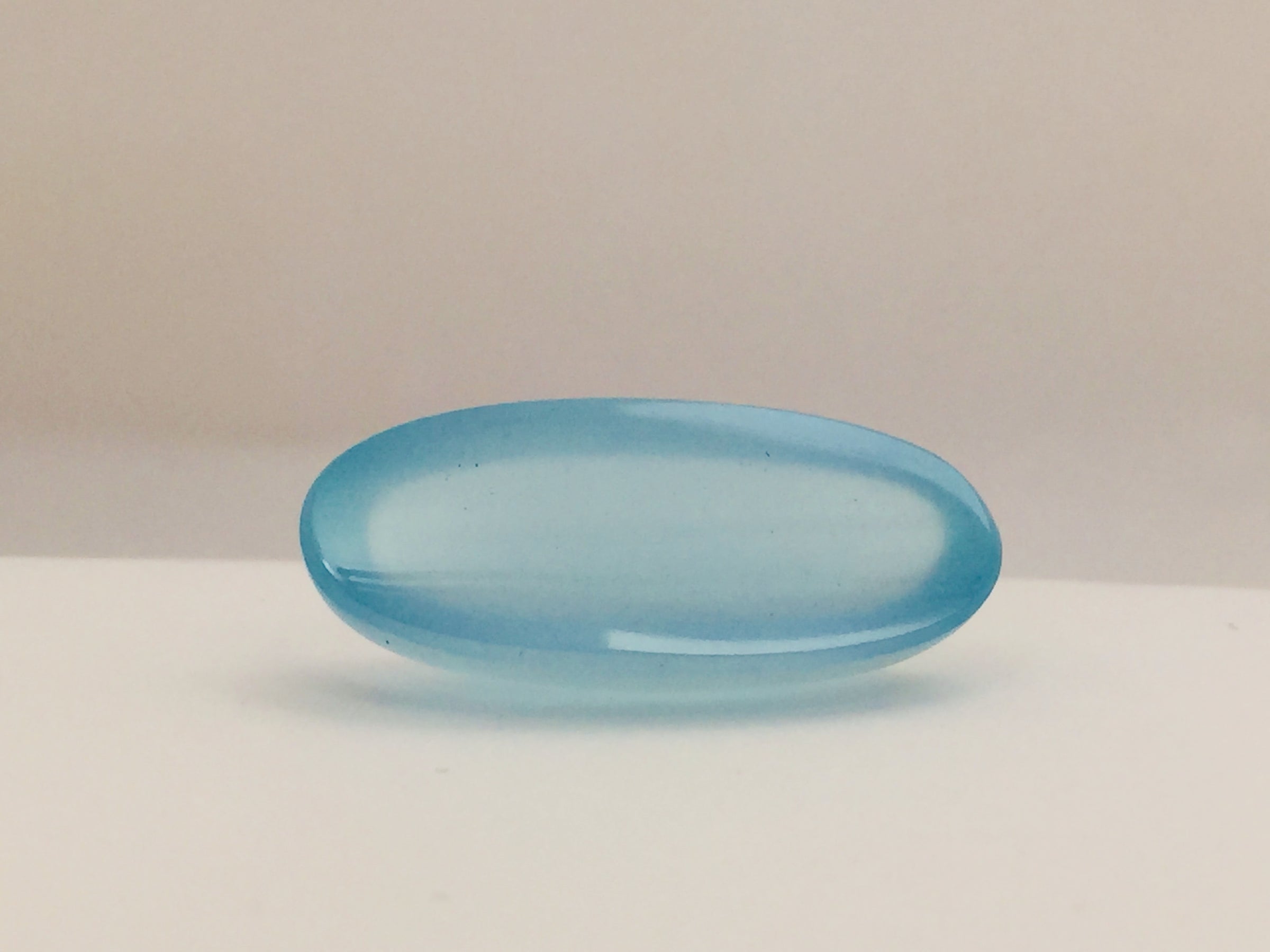 Long light blue aquamarine gem, white background.
