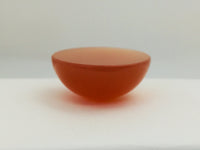 Very large round orange moonstone cabochon gem, white background.