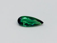 Small pear shape green tourmaline gem, white background.