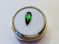 Small pear shape green tourmaline gem, white background.