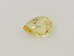 Large pear shaped light yellow chrysoberyl gem, on white background.