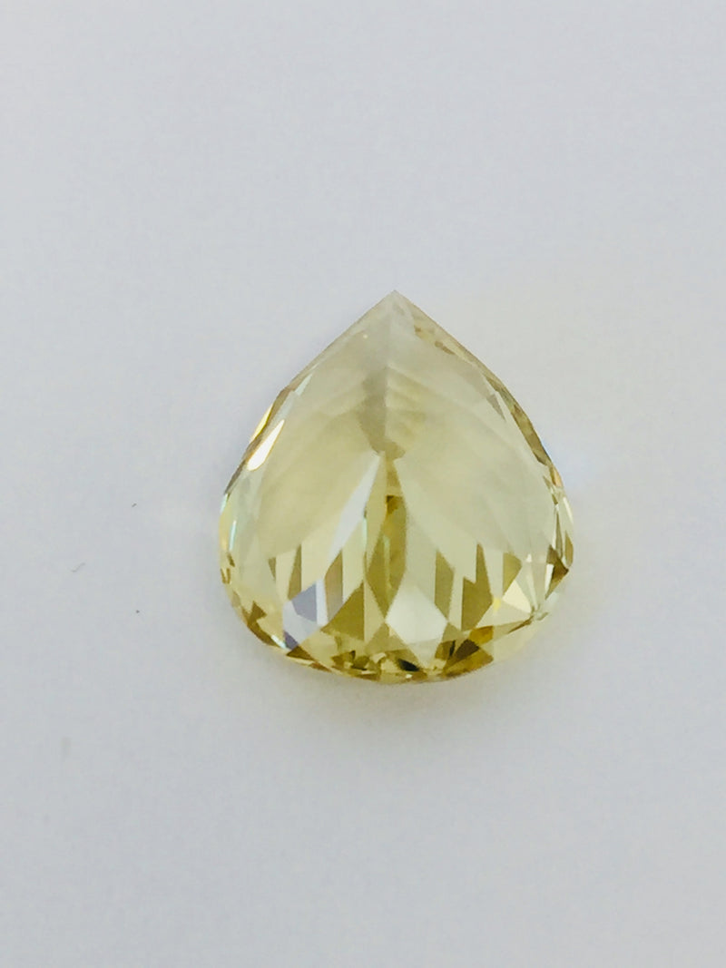 Large pear shaped light yellow chrysoberyl gem, on white background.