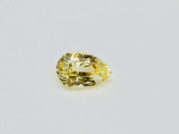 Medium pear-shaped yellow sapphire gem, white background.