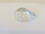 Very large colourless tear-drop shape white topaz gem, white background.