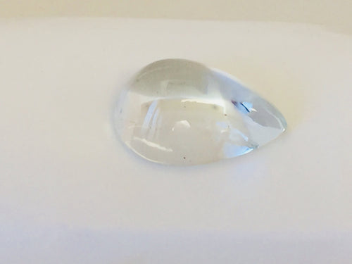 Very large colourless tear-drop shape white topaz gem, white background.