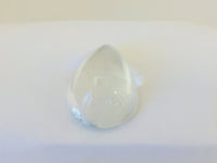 Very large colourless tear-drop shape white topaz gem, white background.