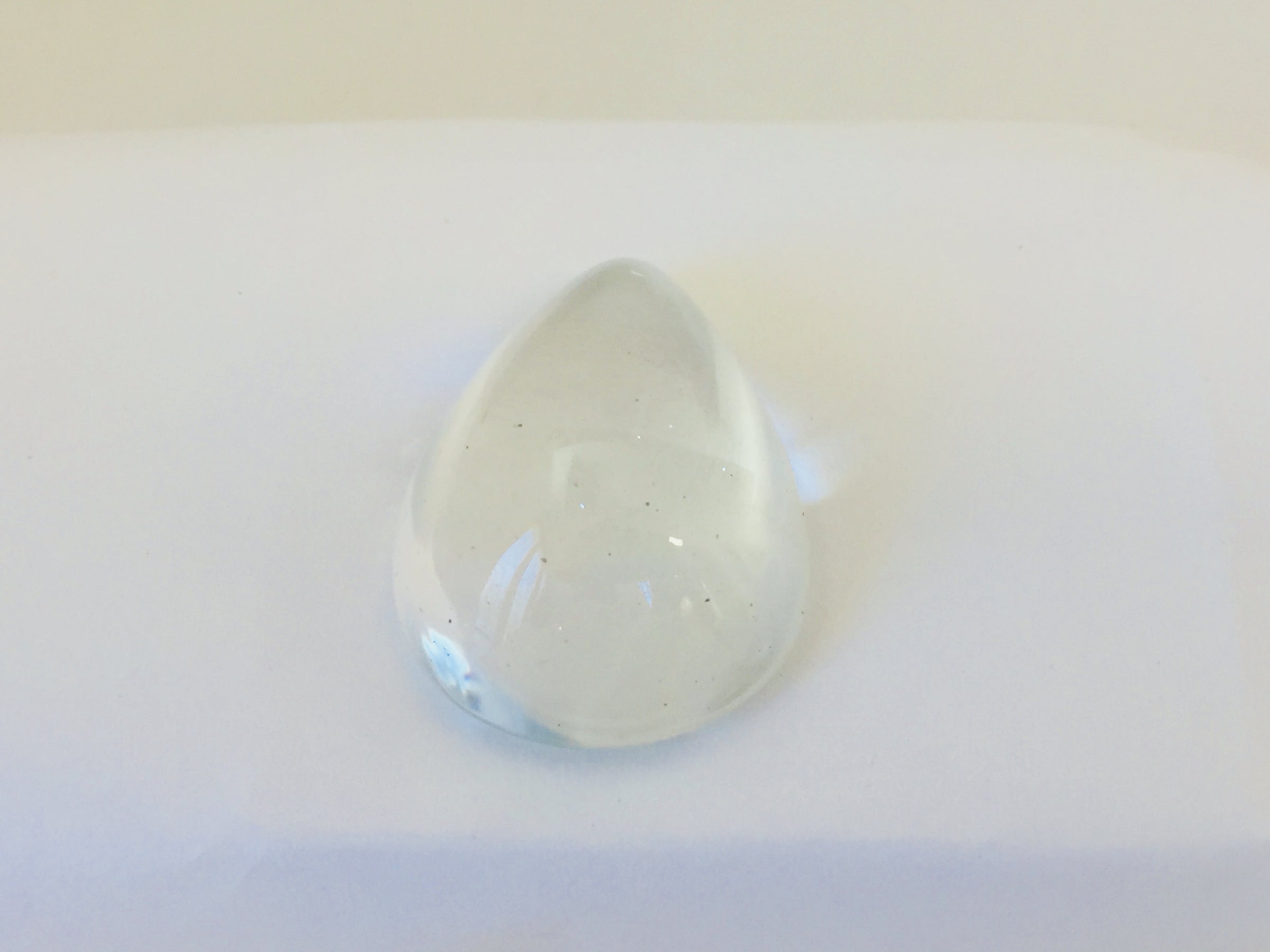 Very large colourless tear-drop shape white topaz gem, white background.