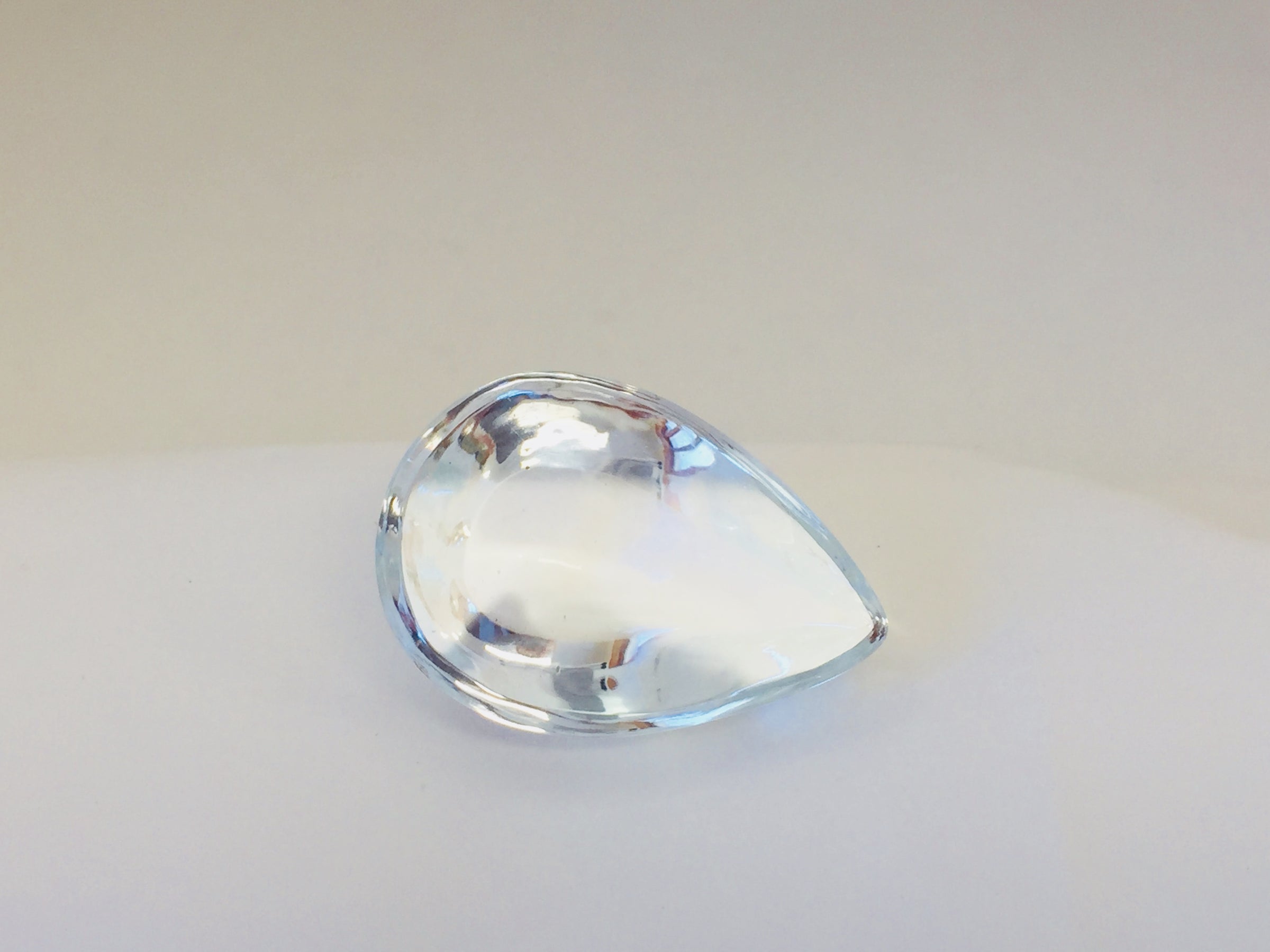 Very large colourless tear-drop shape white topaz gem, white backgroound.