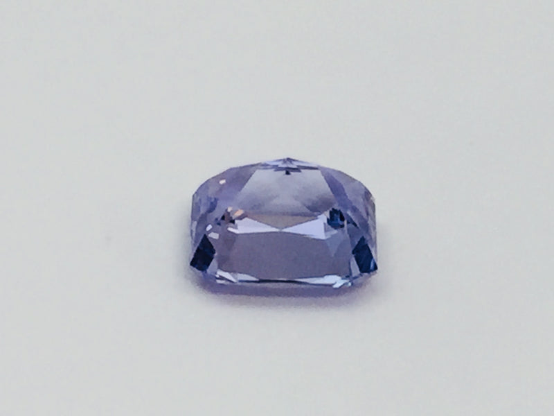 Violet coloured sapphire gem, white background.