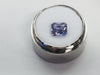 Violet coloured sapphire gem, white background, in gem jar..
