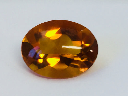 Large oval deep orange citrine gem, on white background.