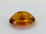 Large oval deep orange citrine gem, on white background.