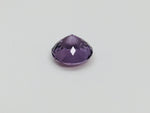 Medium round deep purple spinel gem, on white background.