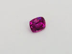 Small rectangle fuschia pink sapphire gem, white background.