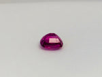 Small rectangle fuschia pink sapphire gem, white background.