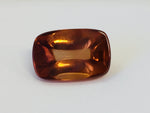 Rectangular deep golden brown cabochon zircon gem, on white background.