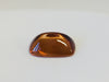 Rectangular deep golden brown cabochon zircon gem, on white background.