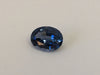 Small oval deep blue spinel gem, white background.