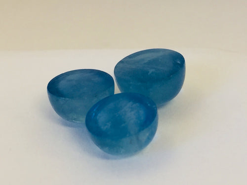 Three medium round medium blue cabochon aquamarine gems, white background.