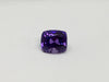 Deep purple coloured sapphire gem, white background.