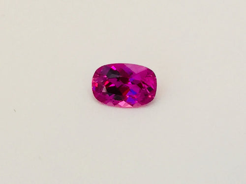 Small rectangle vivid pink sapphire gem, white background.