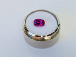 Small rectangle vivid pink sapphire gem, white background, in gem jar.
