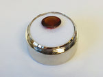 Medium oval deep orange red hessonite garnet gem, white background in gem jar.