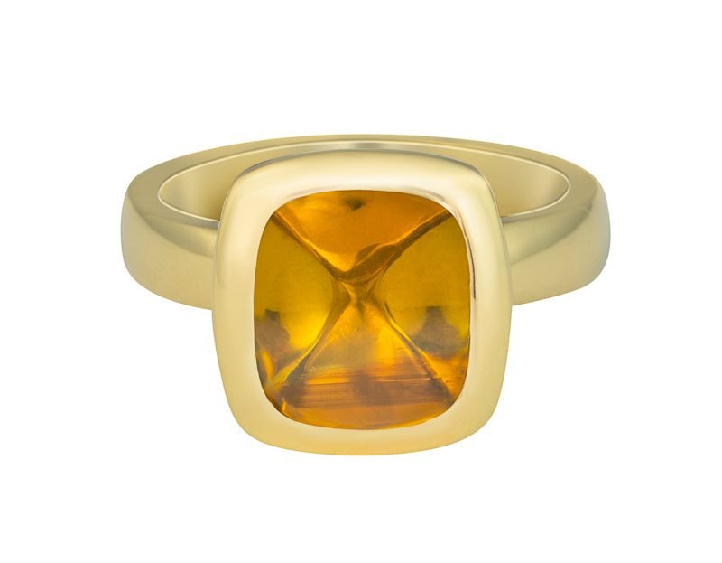 Green gold ring set with upside down medium square cabochon of golden zircon. Gem is set in a frame.