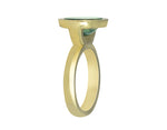 Green gold ring set with upside down large oval cabochon of green zircon. Gem is set in a frame.
