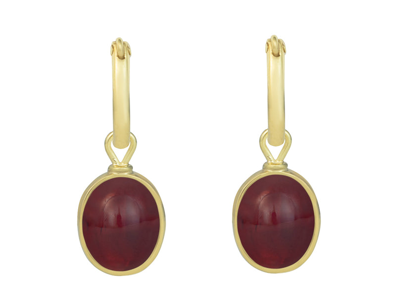 Small oval drops in green gold set with raspberry red gems. Drops hang on small U shaped hoops in solid green gold.