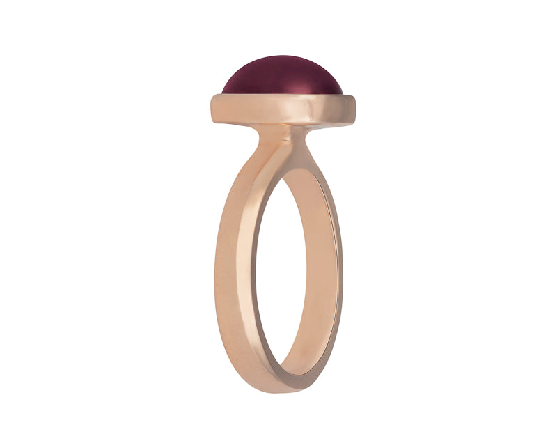 Medium size oval cabochon of raspberry red rhodolite frame set in rose gold ring.