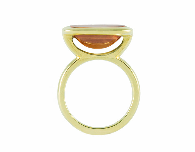 Big green gold ring with large rectangle cabochon of golden zircon set upside down.
