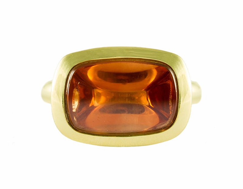 Big green gold ring with large rectangle cabochon of golden zircon set upside down.