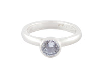 Platinum ring set with round pastel blue sapphire.  The gem is bezel or frame set and sits above the band.